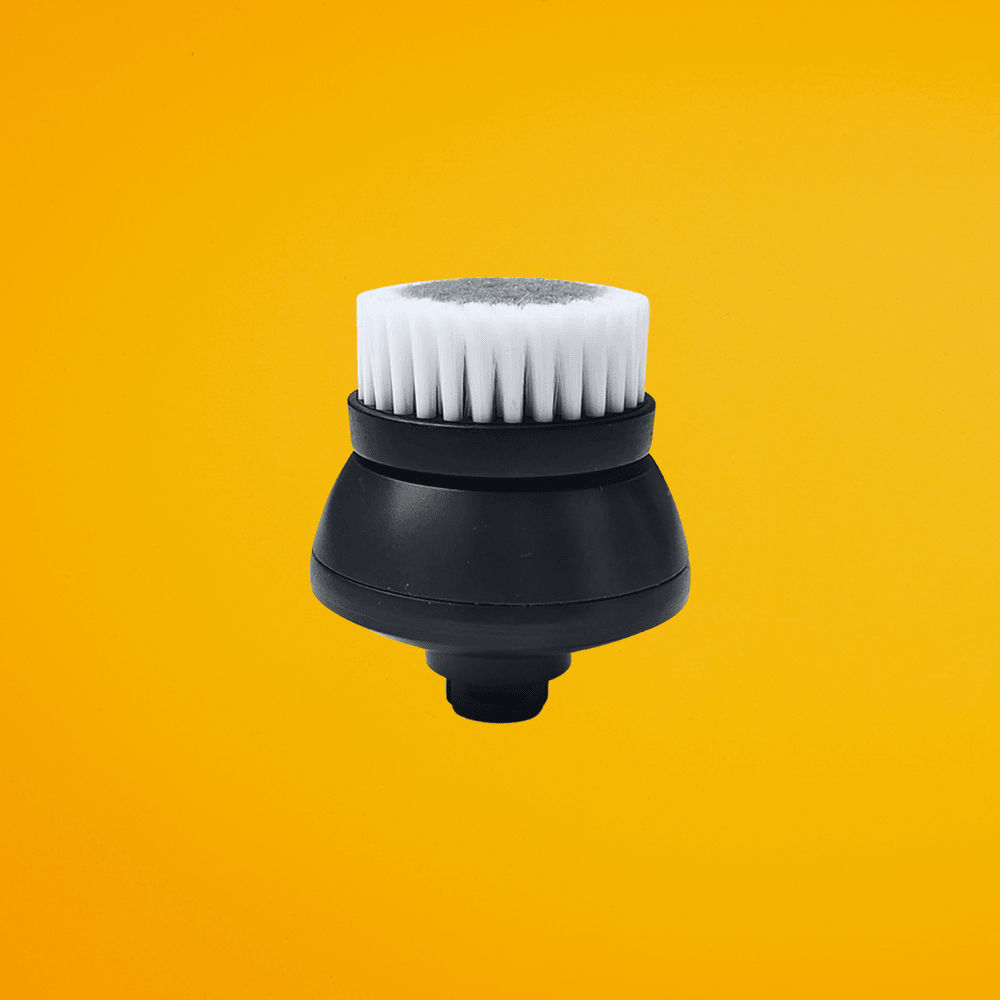 Close-up view of the white bristle cleansing brush head accessory for scalp care.