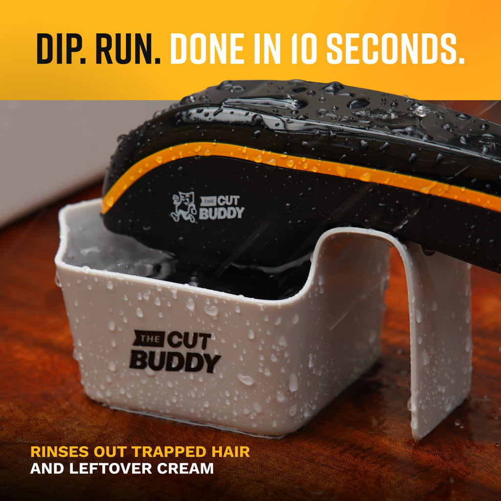 The Cut Buddy hair clipper being dipped into a white cleaning cup to rinse out hair and shaving cream.