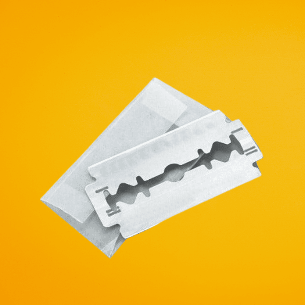 Stainless steel double-edge replacement safety razor blades by The Cut Buddy on a yellow background.