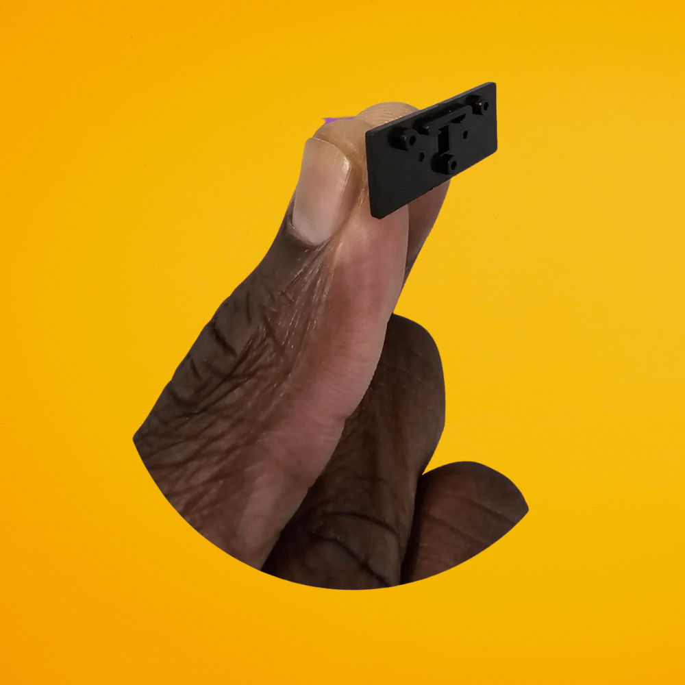 Close-up scale reference of The Cut Buddy trimmer mounting bracket, highlighting its compact and lightweight design.